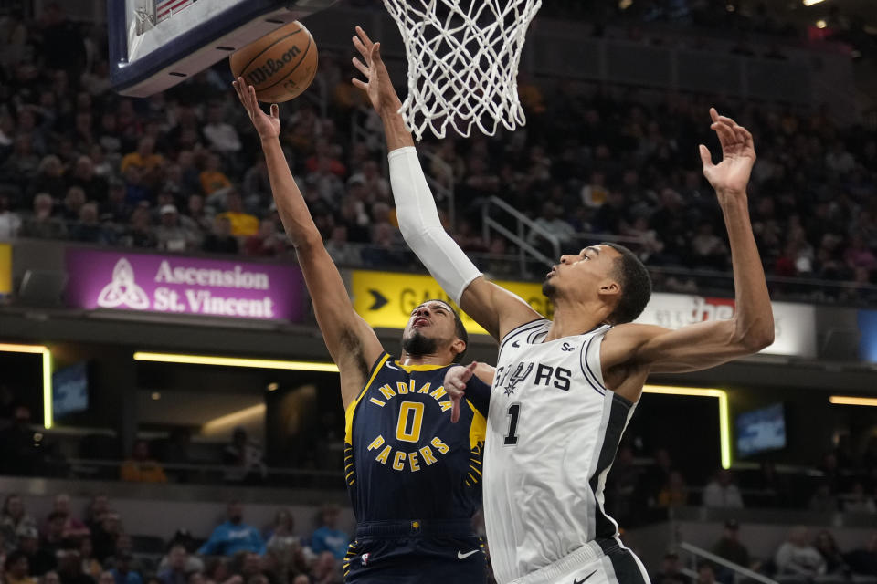 Indiana Pacers guard Tyrese Haliburton (0) shoots under the defense of San Antonio Spurs center Victor Wembanyama (1) during the first half of an NBA basketball game in Indianapolis, Monday, Nov. 6, 2023. (AP Photo/AJ Mast)
