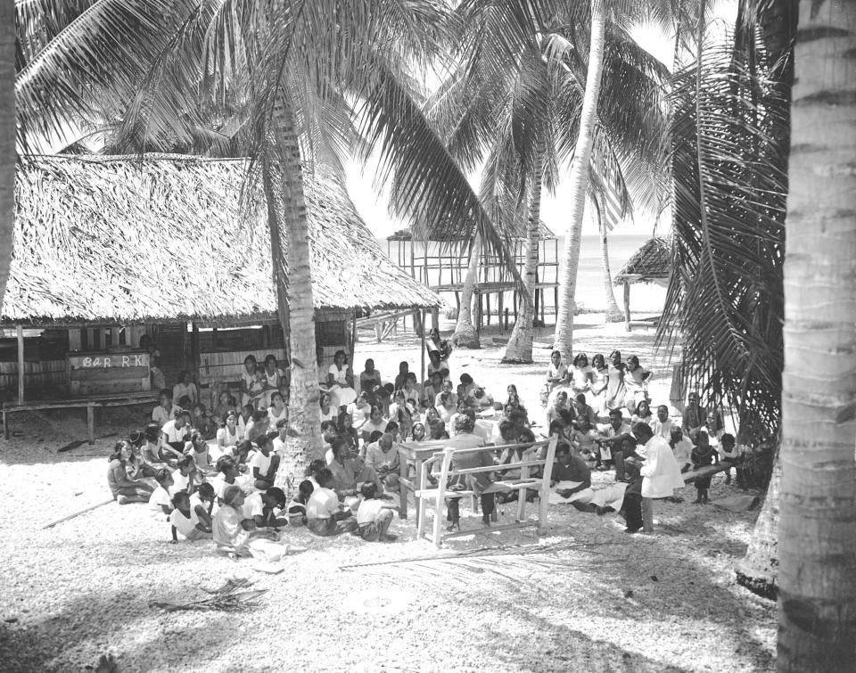 FILE - In this March 16, 1946, file photo, the natives of Bikini Atoll, Marshall Islands, gather in the open for their last church service before being transferred by the U.S. Navy to Rongerik Atoll, 109 miles away. A Texas-based company is facing criticism for naming a beer after the location of nuclear tests that resulted in the contamination of a Pacific island chain, a report said. Manhattan Project Beer Company is under scrutiny by Marshall Islanders who were exposed to high levels of radiation by U.S. government research from 1946 to 1958, The Pacific Daily News reported Thursday, Aug. 15, 2019. The government and residents of the Republic of the Marshall Islands have objected to the company's beer named Bikini Atoll, an area of the island chain that remains uninhabitable. (AP Photo/File)