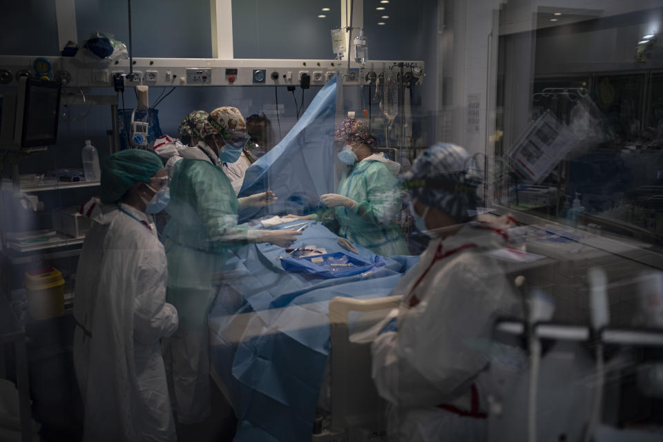 A COVID-19 patient receives treatment in the ICU of the Hospital del Mar, in Barcelona, Spain, Tuesday, Jan. 19, 2021. The unrelenting increase in COVID-19 infections in Spain following the holiday season is again straining hospitals, threatening the mental health of doctors and nurses who have been at the forefront of the pandemic for nearly a year. (AP Photo/Felipe Dana)