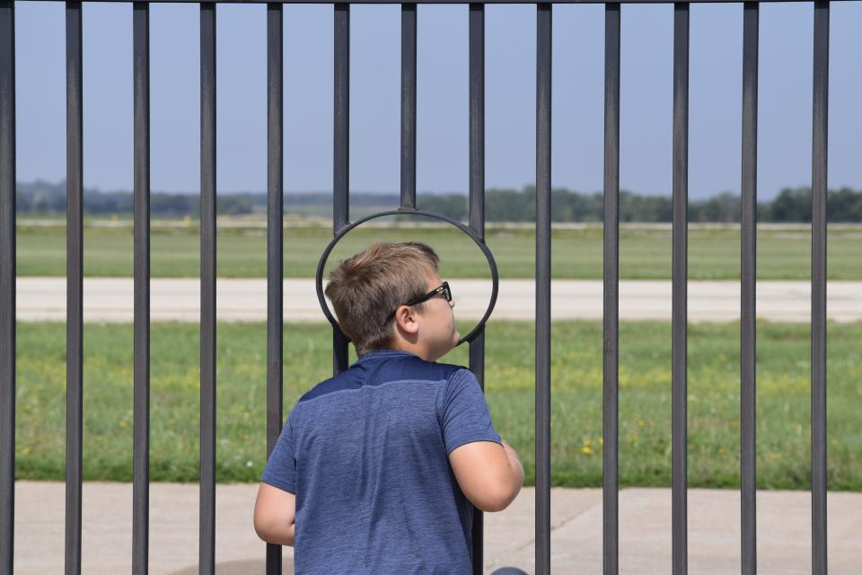 Cole Easterday, 9, of Salina, looks through a viewing hole Tuesday for the KC-46A Pegasus and KC-135R Stratotanker as they fly over the Salina Regional Airport. The two air refuelers flew as low as 2,000 feet above the ground as part of the U.S. Air Force's celebration of 100 years of air refueling.