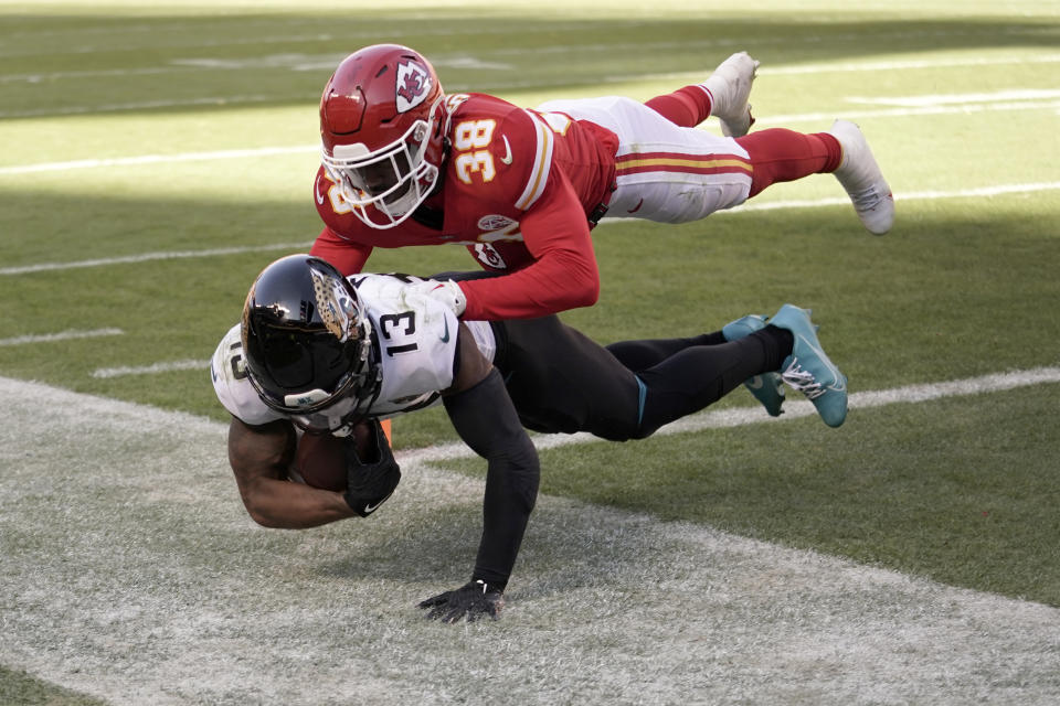 Jacksonville Jaguars wide receiver Christian Kirk (13) catches a touchdown pass as Kansas City Chiefs cornerback L'Jarius Sneed (38) defends during the first half of an NFL football game Sunday, Nov. 13, 2022, in Kansas City, Mo. (AP Photo/Ed Zurga)