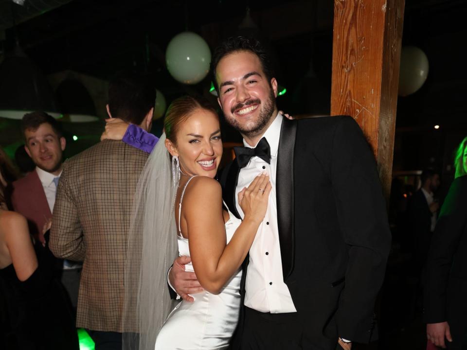 A girl in a white mini skirt and man in a tuxedo.