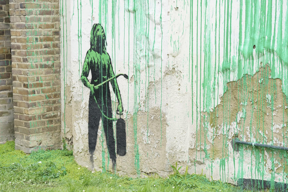 Detail from a tree mural which appeared overnight on a residential building in Finsbury Park, which has been confirmed to be by elusive graffiti artist, Banksy, in London, Monday, March 18, 2024. The artwork in the Finsbury Park neighborhood covers the wall of a three-story building and shows a small figure holding a pressure hose beside a real London plane tree. Green paint has been sprayed across the wall, replicating the absent leaves of the tree, which has been severely cropped. (Jonathan Brady/PA via AP)