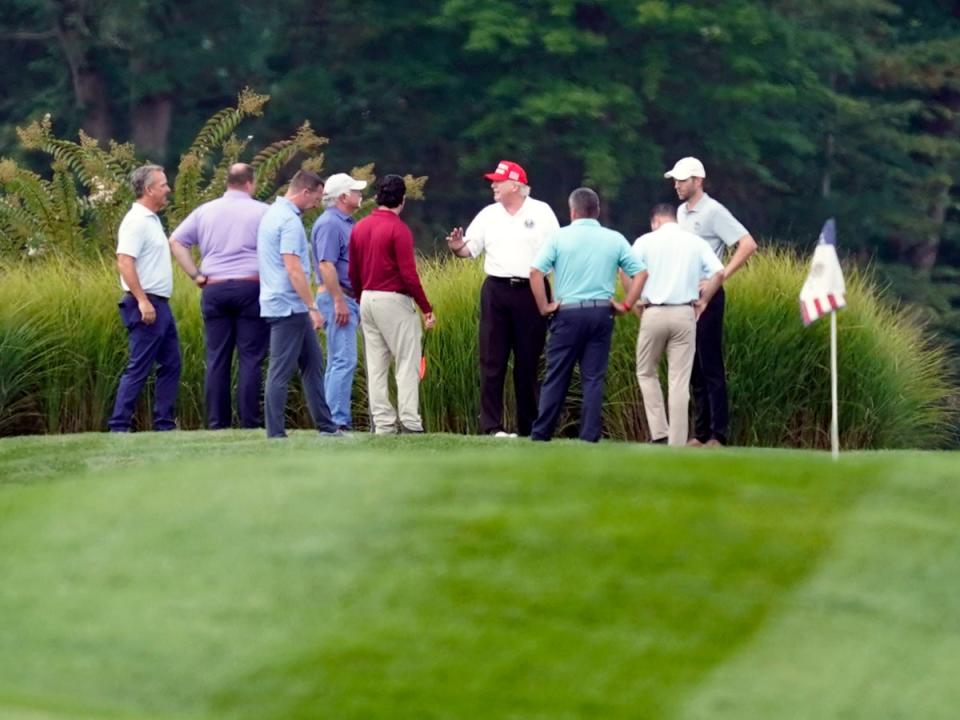 Donald Trump habla con sus asistentes y asesores en el Trump National Golf Club en Sterling, Virginia (AP)