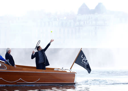 Switzerland's Roger Federer serves a ball from a boat in front of the Jet d'Eau water fountain during a promotion event for the Laver Cup tennis tournament in Geneva, Switzerland February 8, 2019. REUTERS/Arnd Wiegmann