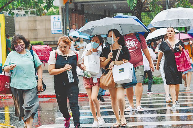 中央氣象局22日對15縣市發布豪、大雨特報，台北市午後下起雷陣雨，驚人雨勢如瀑布般直落而下，民眾即使攜帶雨具仍然一身濕。（郭吉銓攝）