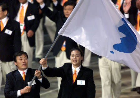 North Korea's Jang Choo Pak (L) and South Korea's Eun-Soon Chung carry a flag bearing the unification symbol of the Korean peninsula during the opening ceremony of the Sydney 2000 Olympic Games, in Sydney, Australia September 15, 2000. REUTERS/Andy Clark/Files