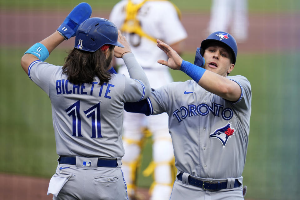 Toronto Blue Jays' Daulton Varsho, right, celebrates with Bo Bichette, left, after they scored on a double by Brandon Belt off Pittsburgh Pirates starting pitcher Johan Oviedo during the first inning of a baseball game in Pittsburgh, Saturday, May 6, 2023. (AP Photo/Gene J. Puskar)