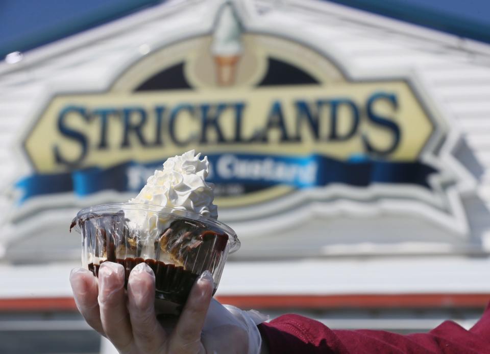 Jacob Margroff, general manager at Stricklands Frozen Custard, holds a MoonPie sundae, which features a MoonPie sandwich with vanilla custard and hot fudge and topped with whipped cream.