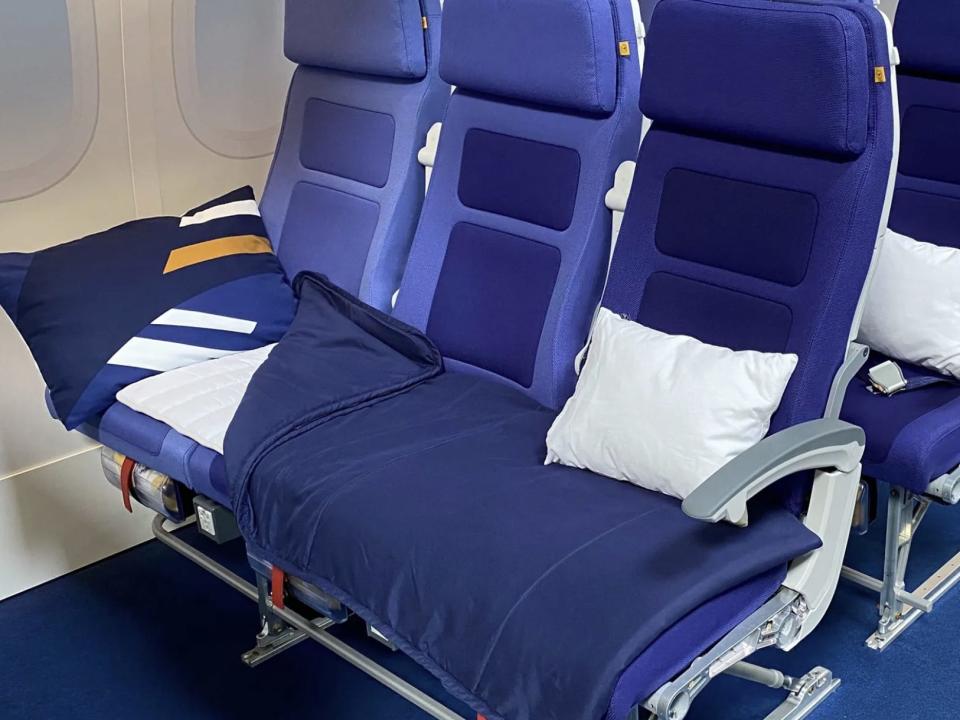 A Sleeper's Row with blue bedding on a Lufthansa flight.