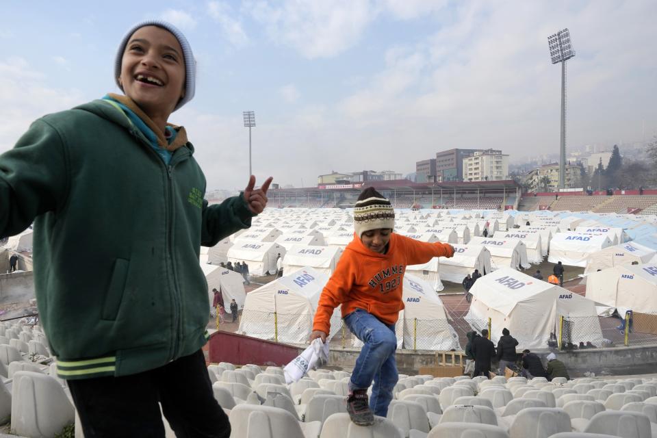 Children play at a stadium where tents have been setup to accommodate earthquake survivors, in Kharamanmaras, southeastern Turkey, Friday, Feb. 10, 2023. Rescuers pulled several people alive from the shattered remnants of buildings on Friday, some who survived more than 100 hours trapped under crushed concrete in the bitter cold after a catastrophic earthquake slammed Turkey and Syria. (AP Photo/Kamran Jebreili)