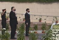 U.S. Secretary of State Mike Pompeo, center, and Secretary of Defence Mark Esper pay their tributes at the National War Memorial in New Delhi, India, Tuesday, Oct. 27, 2020. In talks on Tuesday with their Indian counterparts, Pompeo and Esper are to sign an agreement expanding military satellite information sharing and highlight strategic cooperation between Washington and New Delhi with an eye toward countering China. (Jewel Samad/Pool via AP)