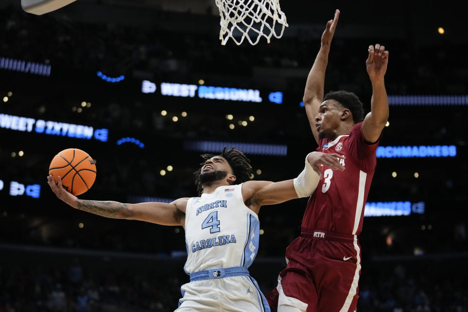 North Carolina guard RJ Davis (4) shoots past Alabama guard Rylan Griffen (3) during the first half of a Sweet 16 college basketball game in the NCAA tournament Thursday, March 28, 2024, in Los Angeles. (AP Photo/Ashley Landis)