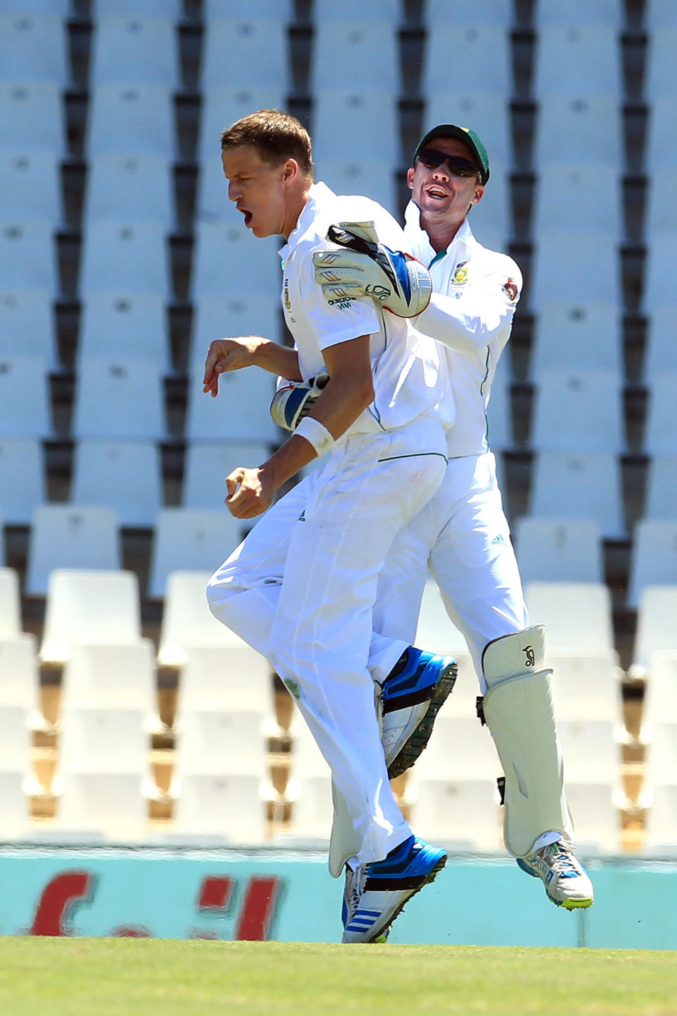 South Africa's Morne Morkel, left, celebrates with teammate AB de Villiers, right, after dismissing Australia's Chris Rogers, for 4 runs on the first day of their cricket test match at Centurion Park in Pretoria, South Africa, Wednesday, Feb. 12, 2014. (AP Photo/ Themba Hadebe)