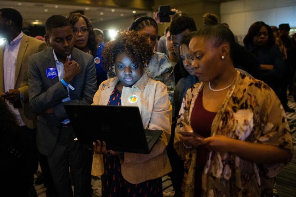 Attendees look at a laptop computer during an election night watch party for Stacey Abrams, Democratic nominee for governor of Georgia, not pictured, in Atlanta, Georgia, U.S., on Tuesday, Nov. 6, 2018.