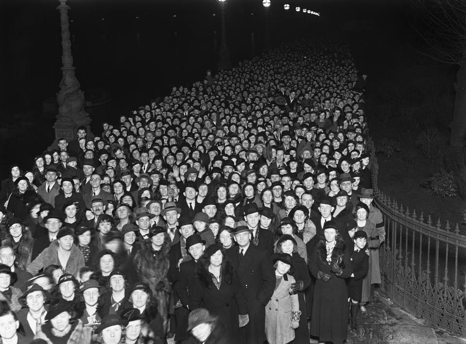 ARCHIVO – La enorme fila de dolientes hacia el Salón Westminster para rendir homenaje al rey Jorge V, segía teniendo dos millas de largo en Londres el 26 de enero de 1936. Isabel II recibe honores de Estado de cuerpo presente en el Salón Westminster en el Palacio de Westminster en Londres el miércoles 14 de septiembre de 2022. Los restos de la reina permanecerán en el salón hasta horas antes de su funeral de Estado el lunes. Se espera que acudan cientos de miles de personas a despedirse. (Foto AP, archivo)