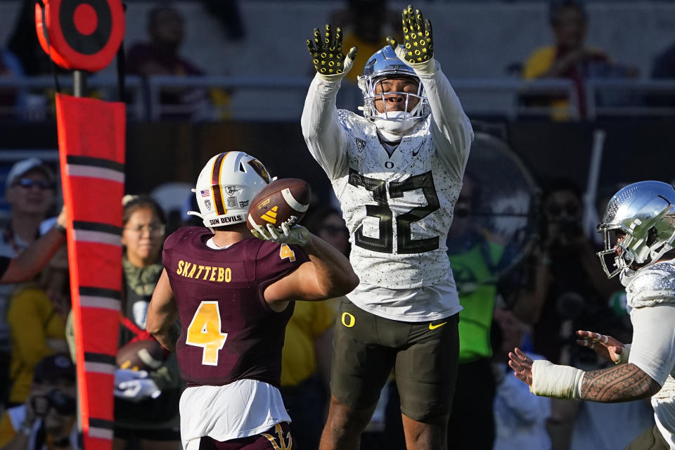 Arizona State running back Cameron Skattebo (4) throws under pressure from Oregon linebacker Emar'rion Winston (32) during the first half on an NCAA college football game, Saturday, Nov. 18, 2023, in Tempe, Ariz. (AP Photo/Matt York)