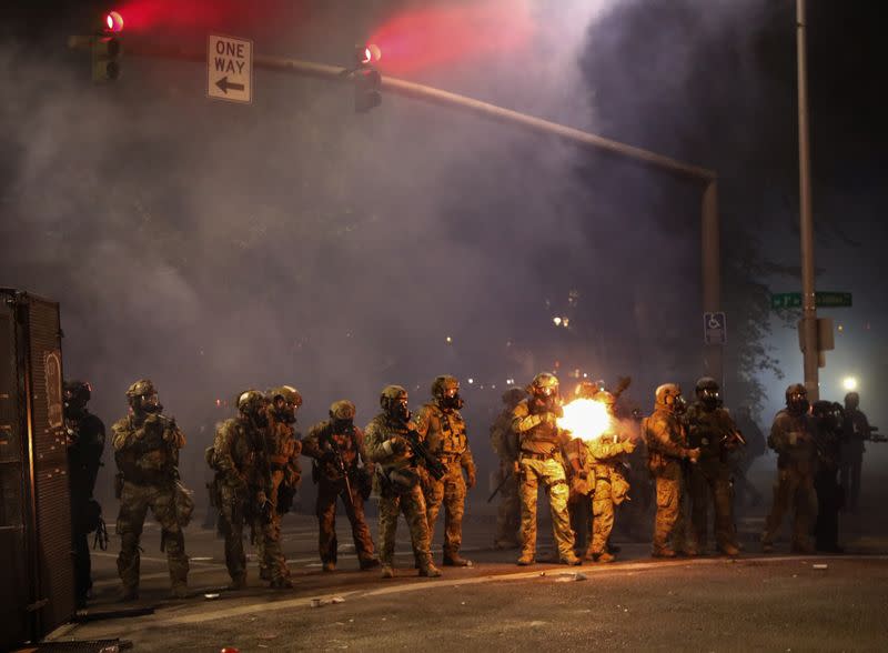 Federal law enforcement officers deployed under the Trump administration's new executive order face off with protesters