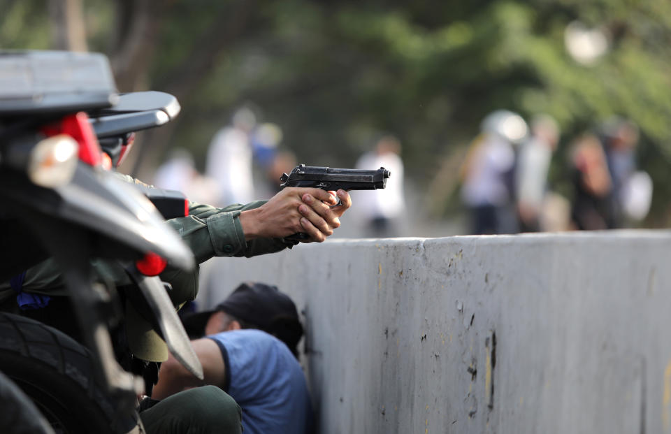 A military member aims a gun near the Generalisimo Francisco de Miranda Airbase in Caracas