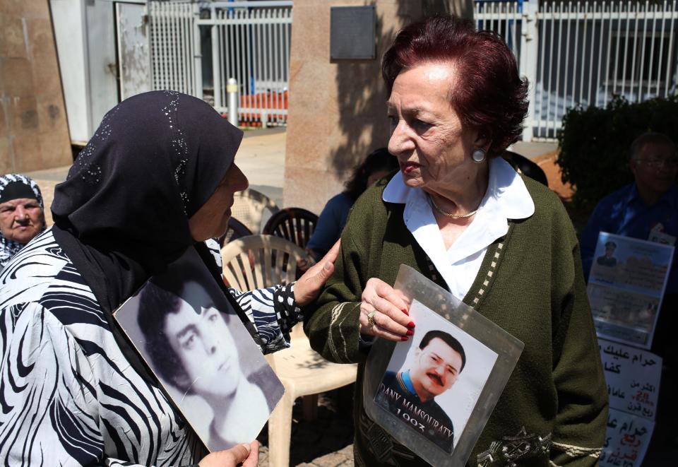 Lebanese Mary Mansourati, 82, right, who her son Dani went missing in Syria in 1992 at the age of 30, holds his portrait as she speaks with Majida Bashasha, 60, who holds a portrait of her brother Ahmad who was kidnapped in 1975 at the age of 18, as they mark the ninth anniversary of an ongoing sit-in, in front the U.N headquarters in downtown Beirut, Lebanon, Friday April 11, 2014. Dani and Ahmad are two among an estimated 17,000 Lebanese still missing from the time of Lebanon’s civil war or the years of Syrian domination that followed. Syria’s civil war has added new urgency to the plight of their families, many of whom are convinced their loved ones are still alive and held in Syrian prisons, at risk of being lost or killed in the country’s mayhem. (AP Photo/Hussein Malla)
