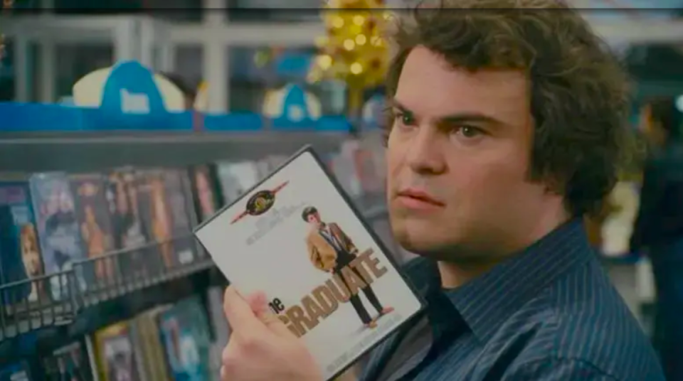 Jack Black in a video store holding up The Graduate