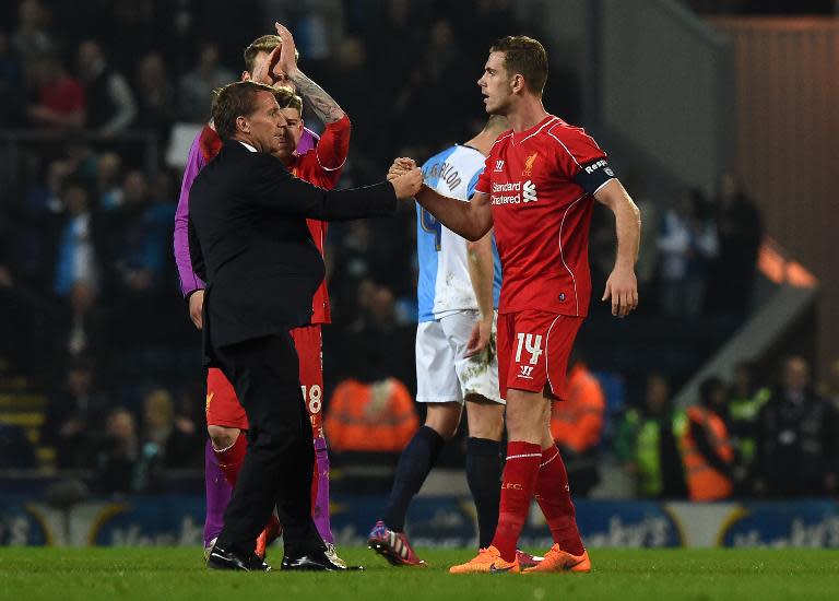 Liverpool manager Brendan Rodgers (L) celebrates on the pitch with Jordan Henderson after the English FA Cup quarter-final replay against Blackburn Rovers at Ewood Park on April 8, 2015