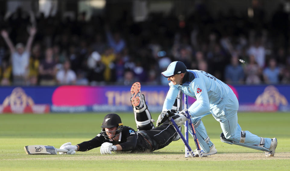 England's Jos Buttler runs out New Zealand's Martin Guptill during the Super Over in the Cricket World Cup final match between England and New Zealand at Lord's cricket ground in London, England, Sunday, July 14, 2019. (AP Photo/Aijaz Rahi)