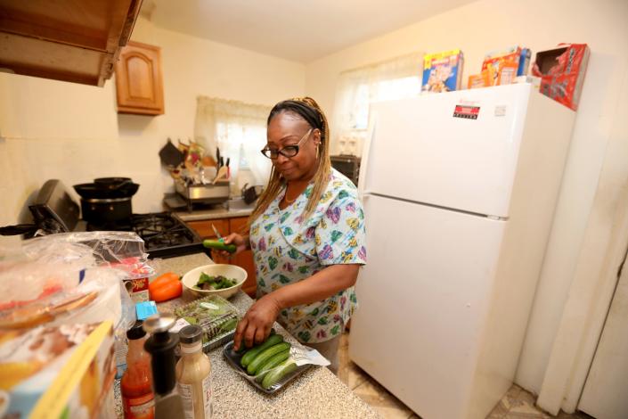 Angela Washington, 57, prepares a salad for dinner in her Mount Vernon home Nov. 17, 2021. Washington, who works as a home health aide, had her hours cut during the Covid-19 pandemic, resulting in her falling about eight months behind on her rent. Washington was able to stay in her home with held from New York State&#39;s Emergency Rental Assistance Program. New York State has ended the $2.4 billion program, as tenants have overwhelmed the system.
