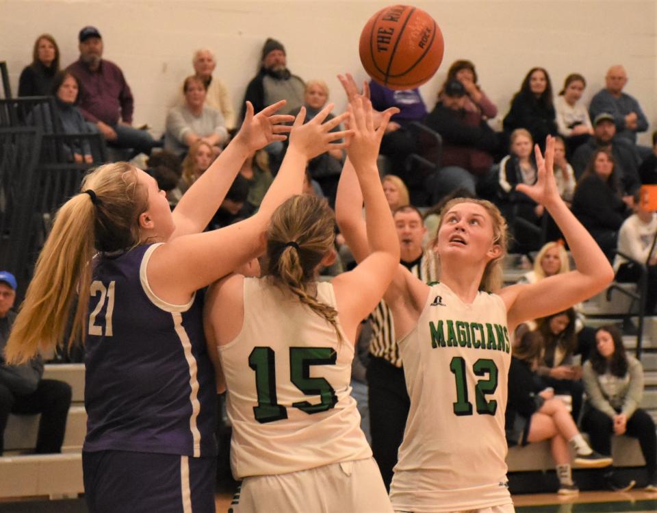 West Canada Valley Indian Ava Fellows (21) and Herkimer Magicians Danielle Gilbert (15) and Madison Marusic (12) reach for a loose ball Friday.