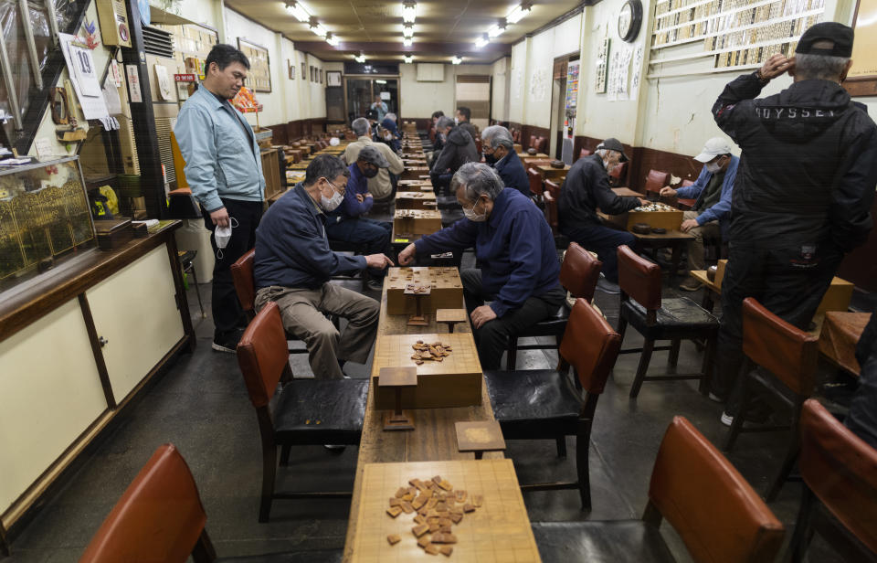 People play "shogi," a game similar to chess, before the parlor closes to follow the government measures against the coronavirus in Osaka, western Japan, Monday, April 19, 2021. (AP Photo/Hiro Komae)