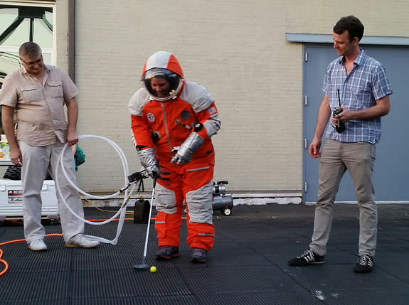 NASTAR space training center director Brienna Henwood puts a golf ball while wearing a Final Frontier Design spacesuit during the Brooklyn, New York-based company's Spacesuit Experience launch party atop a Brooklyn Navy Yards rooftop on Aug. 28