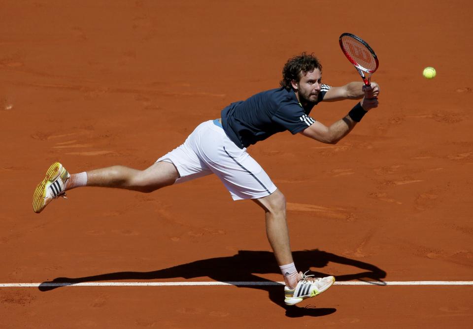 Ernests Gulbis of Latvia returns the ball to Novak Djokovic of Serbia during their men's semi-final match at the French Open tennis tournament at the Roland Garros stadium in Paris June 6, 2014. REUTERS/Gonzalo Fuentes (FRANCE - Tags: SPORT TENNIS)