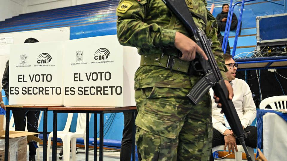 A soldier stands guard next to employees of the National Electoral Council during a drill ahead of Sunday's presidential elections in Quito on August 13, 2023. - Martin Bernetti/AFP/Getty Images