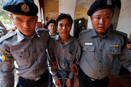 Detained Reuters journalist Kyaw Soe Oo is escorted by police after a court hearing in Yangon, Myanmar February 1, 2018. REUTERS/Jorge Silva/Files