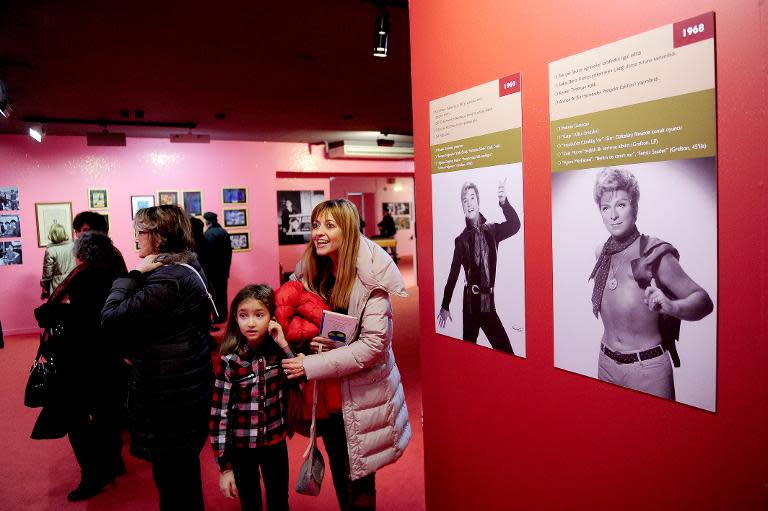 Visitors look round the "Here I am, Zeki Muren" exhibution on December 20, 2014 in Istanbul