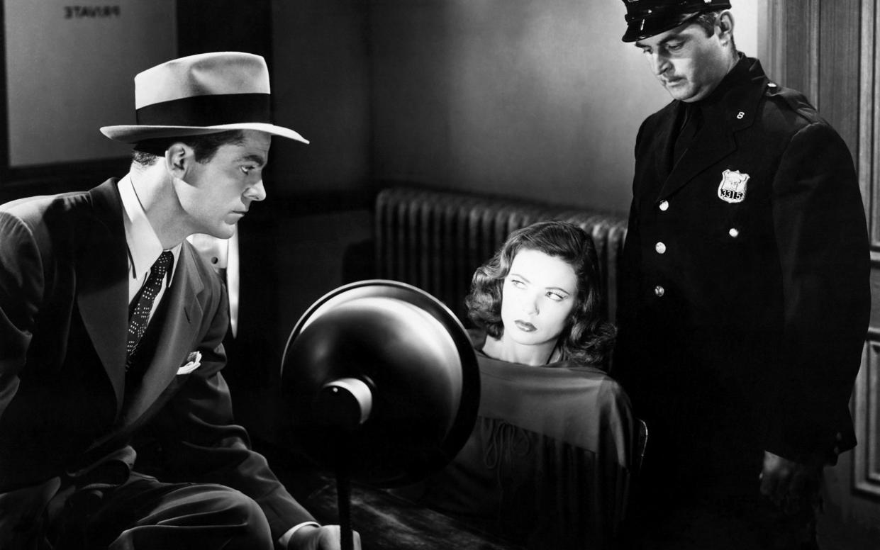 Gene Tierney under the spotlight opposite Dana Andrews in a scene from the classic film noir, Laura