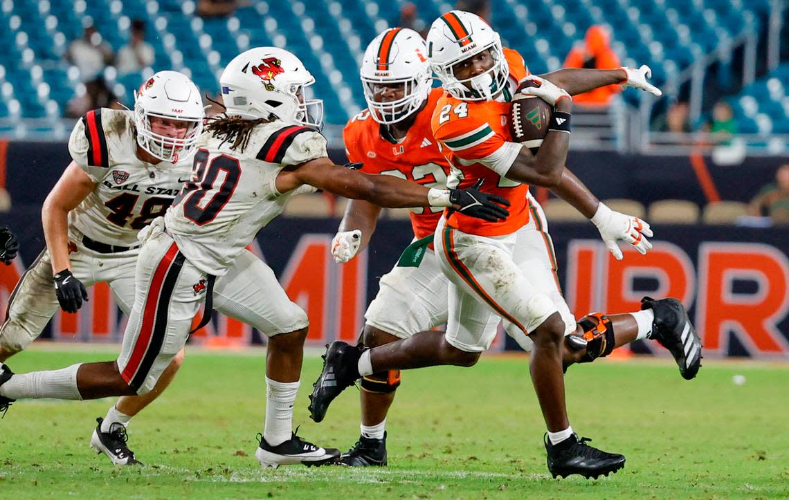 Miami Hurricanes running back Chris Johnson Jr. (24) on a carry as Ball State Cardinals defensive back Jalon Jones (30) defends in the second half of an NCAA football game at Hard Rock Stadium in Miami Gardens, Florida on Saturday, September 14, 2024.