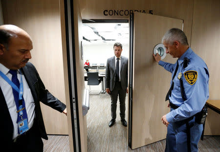 U.N. security staff closes the doors for a meeting between Bashar Al-Ja'afari (3L), Syrian chief negotiator and Ambassador of the Permanent Representative Mission of the Syria to UN in New York and UN Special Envoy for Syria Staffan de Mistura during the Intra Syria talks, at the European headquarters of the United Nations in Geneva, Switzerland March 29, 2017. REUTERS/Denis Balibouse