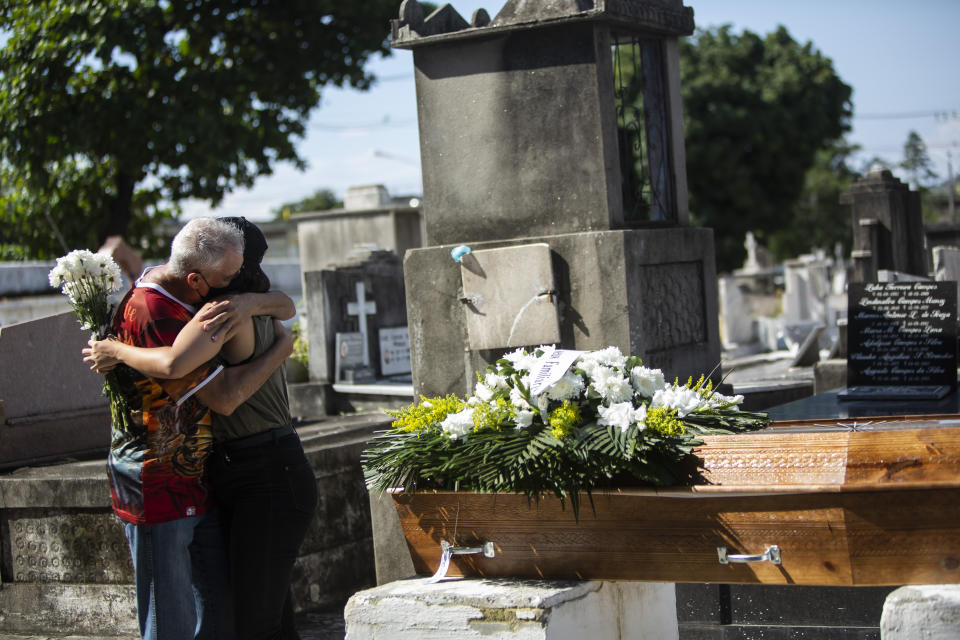 Relatives grieve during the burial service for Monica Cristina, 49, who died from complications related to COVID-19, at the Inahuma cemetery in Rio de Janeiro, Brazil, Wednesday, April 28, 2021. Some 2,400 people have died every day over the past week, triple the amount in the U.S. (AP Photo/Bruna Prado)