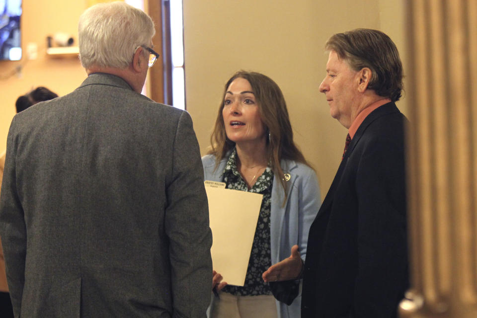 Kansas state Reps. Jerry Stogsdill, left, D-Prairie Village, Kristey Williams, center, R-Augusta, and Steve Huebert, right, R-Valley Center, confer in a hallway during a break in negotiations with the Senate over education policy at the Statehouse, Thursday, April 8, 2021, in Topeka, Kan. Williams and Huebert agreed with senators to push forward a proposed ban on transgender athletes in girls' and women's school sports, but Stogsdill has called the measure "morally wrong." (AP Photo/John Hanna)