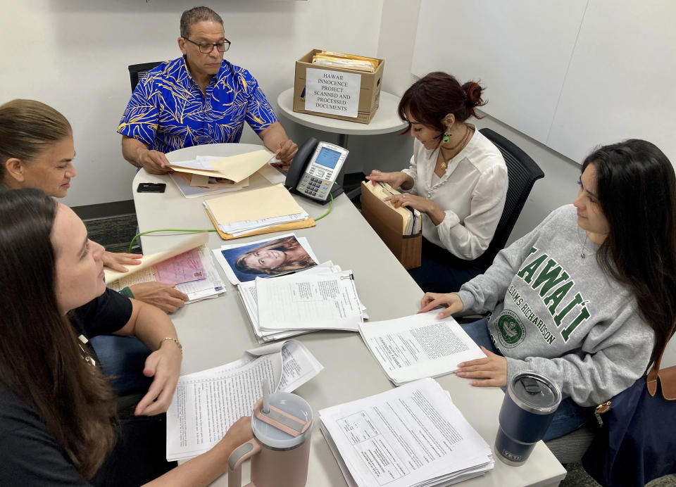 Hawaii Innocence Project co-director Kenneth Lawson, background center, and law students go over files and photos related to the 1991 murder of Dana Ireland in Honolulu on Tuesday, Jan. 17, 2023. A petition filed Monday, Jan. 23 outlining new evidence in one of Hawaii's biggest criminal cases asks a judge to release Albert “Ian” Schweitzer, a Native Hawaiian man who has spent more than 20 years in prison for the sexual assault, kidnapping and murder of Ireland, a white woman, on the Big Island. (AP Photo/Jennifer Sinco Kelleher)