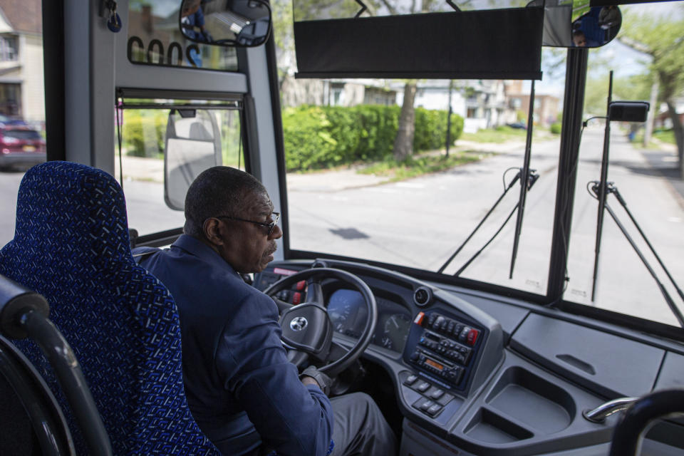 Tommy Seay Sr., a driver with Niagara Scenic Tours, drives to a Tops supermarket located miles away to pick up a shopper, Tuesday, May 17, 2022, in Buffalo, N.Y. In an effort to help shoppers who live near the Tops Friendly Markets location closed due to the shooting, Tops is offering a shuttle to transport people to another location miles away to shop. (AP Photo/Joshua Bessex)