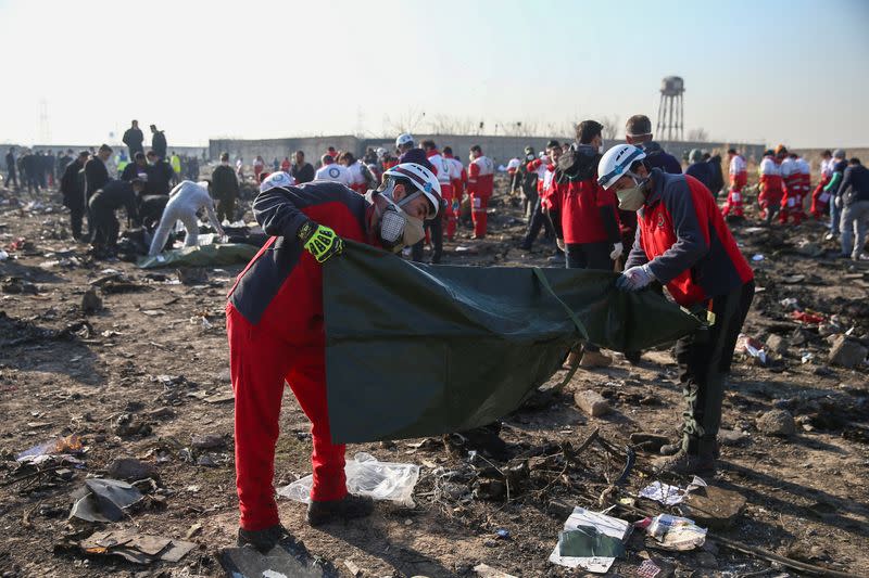 Red Crescent workers check plastic bags at the site where the Ukraine International Airlines plane crashed after take-off from Iran's Imam Khomeini airport, on the outskirts of Tehran