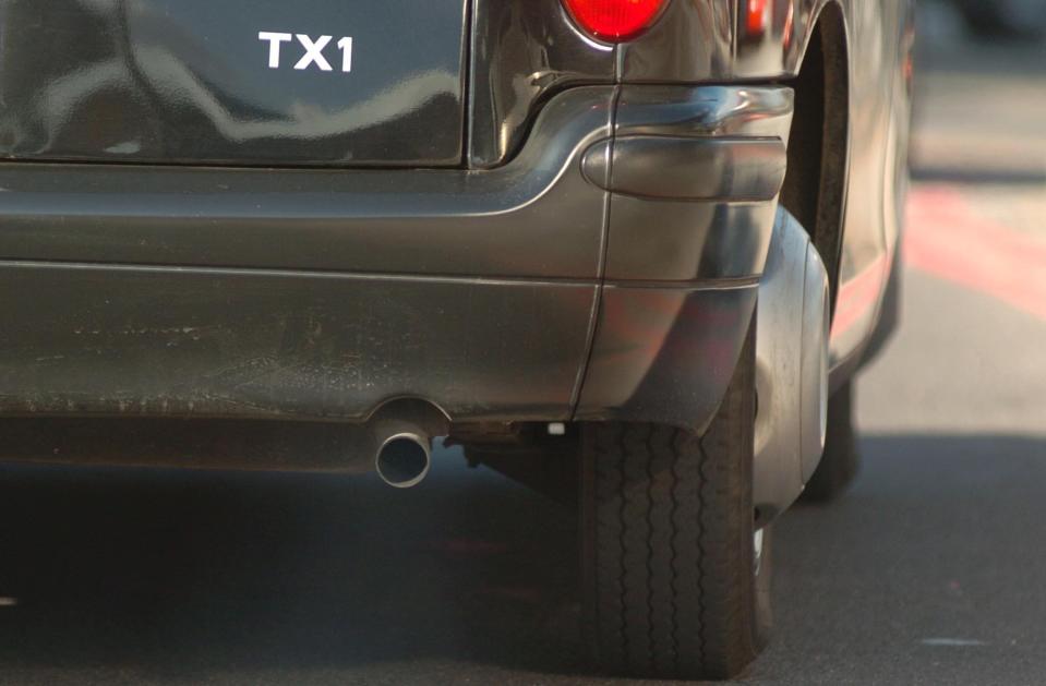 A black cab pumps exhaust fumes into the air in south London (PA Archive)