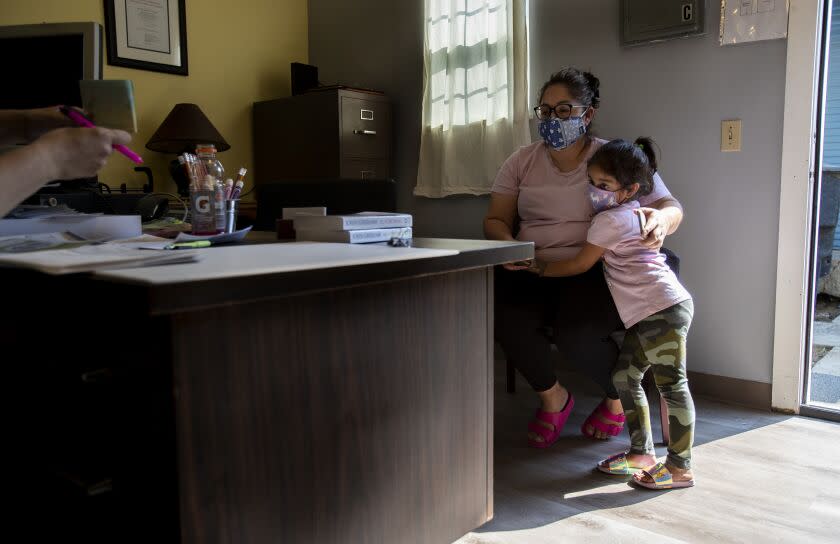 LIVINGSTON, CA - OCTOBER 15, 2020: Undocumented worker Janette Hernandez with her daughter Janely, 5, sits in Rev. Frances Le Bas's office to receive a $1,000 check to help cover expenses since the coronavirus pandemic has hit essential Latino workers very hard in the San Joaquin Valley on October 15, 2020 in Livingston, California. (Gina Ferazzi / Los Angeles Times)