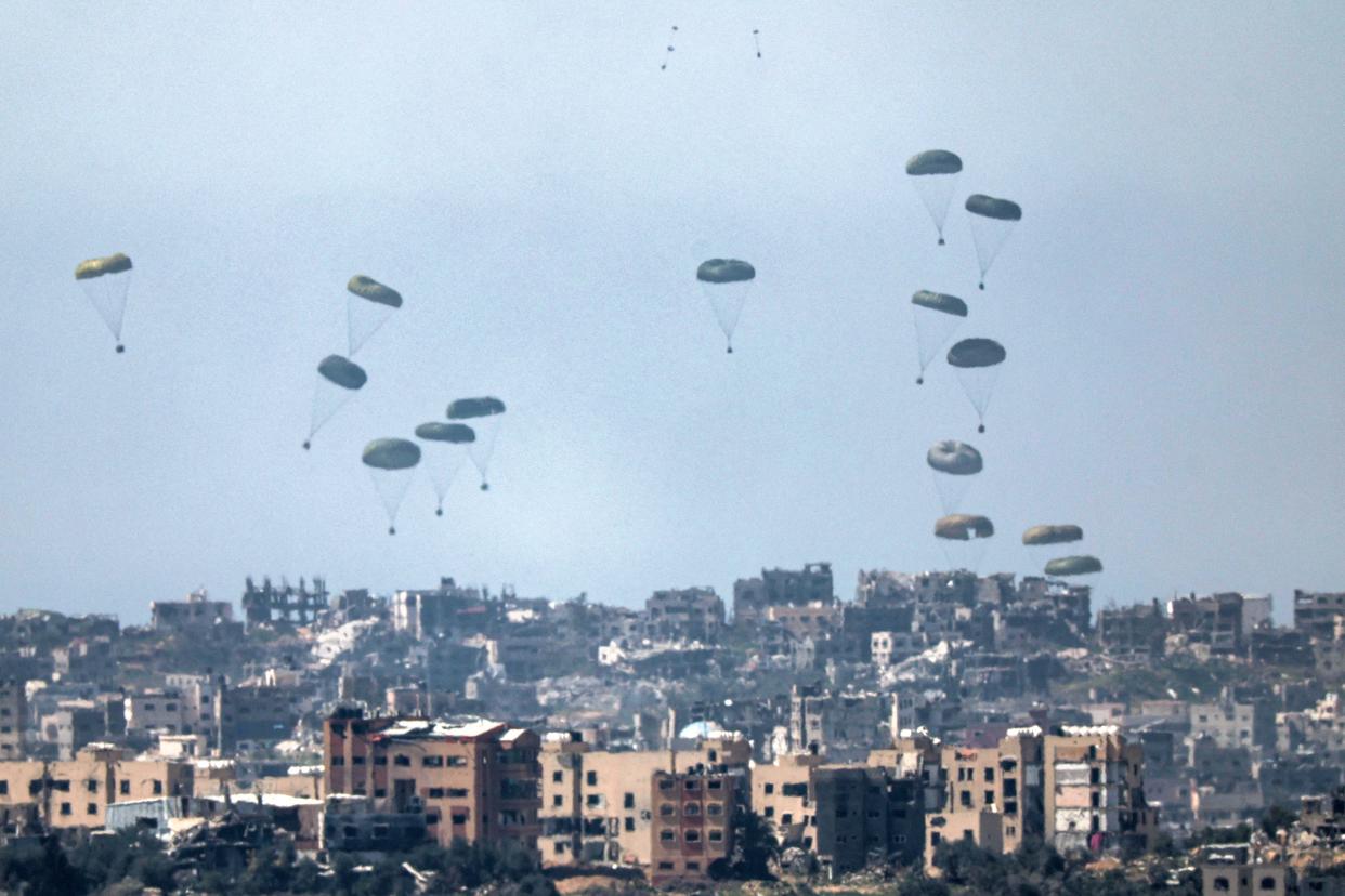 This picture taken from Israel's southern border with the Gaza Strip shows humanitarian aid being airdropped over the Palestinian territory on March 13, 2024.