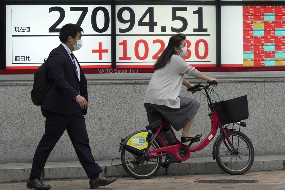 People pass by an electronic stock board showing Japan's Nikkei 225 index at a securities firm Wednesday, Oct. 5, 2022, in Tokyo. Hong Kong’s share benchmark soared more than 5% on Wednesday as Asian shares tracked gains on Wall Street. (AP Photo/Eugene Hoshiko)