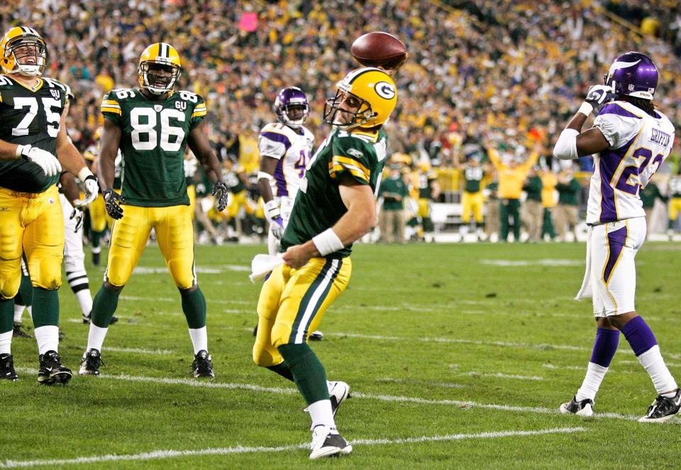 Aaron Rodgers spikes the ball after rushing for a touchdown against the Vikings in his first NFL start.