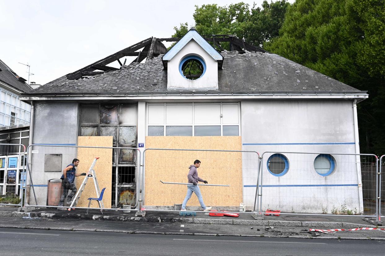 Workers secure a burnt annex building of the city hall in Nantes, western France (AFP via Getty Images)