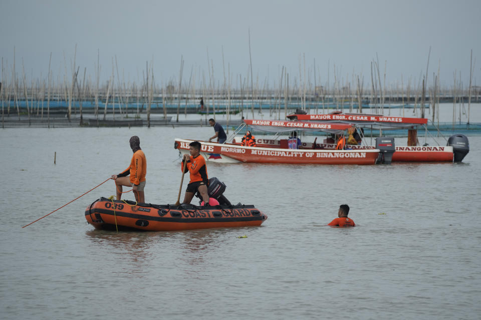 Rescuers search for victims of a capsized passenger boat in Rizal, Philippines, Friday, July 28, 2023. A ferry turned upside down when passengers suddenly crowded to one side in panic as fierce winds pummeled the wooden vessel, killing a number of people, officials said Friday. (AP Photo/Aaron Favila)